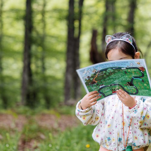 niña sosteniendo mapa de kit de explorador en el Encanto de Picos de Europa