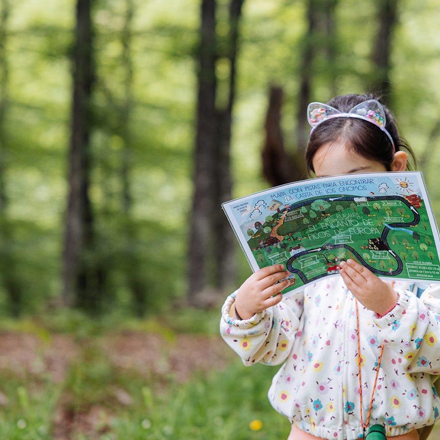 niña sosteniendo mapa de kit de explorador en el Encanto de Picos de Europa